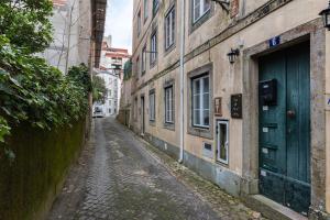 un vicolo vuoto con una porta verde su un edificio di The Point - Sintra 2 a Sintra