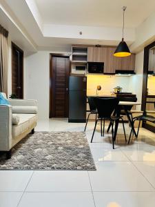 セブシティにあるKR's Cozy 2-Bedroom Unit at Horizons 101のテーブルと椅子のあるキッチンとリビングルーム +1枚の写真