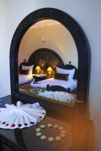 a bedroom with two beds and a mirror at Hôtel Riad Salam Agadir in Agadir