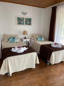 two beds in a room with towels on them at Teanehi Bed & Breakfast in Hanga Roa