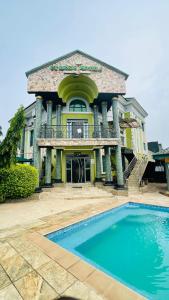 una grande casa con una piscina di fronte di St. Regis Hotel & Resort - Benin City a Benin City