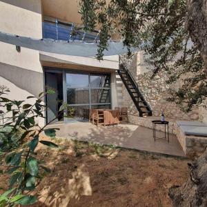 a house with a patio with chairs and a staircase at Sea View Garden Suites in Piraeus