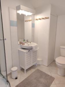 Un baño blanco con lavabo e inodoro. en Studio au coeur de Guérande, en Guérande 13 fotos más