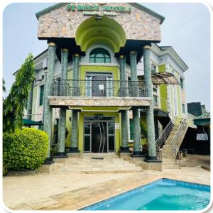 una casa con piscina frente a ella en St. Regis Hotel & Resort - Benin City, en Benin City