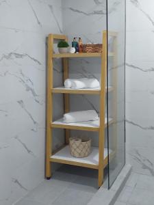 a wooden shelf with towels on it in a bathroom at Seaside Escape Apartment in Flic-en-Flac