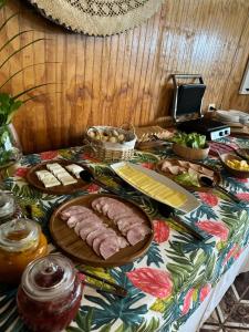 a table with meat and other food on it at Teanehi Bed & Breakfast in Hanga Roa