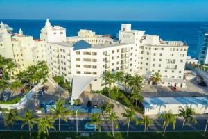a large white building with palm trees and the ocean at Cyan Cancun Resort & Spa in Cancún