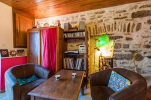 a living room with a wooden table and two chairs at L'authentique maison bretonne - Guingamp centre in Guingamp +9 photos