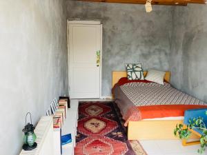 阿達拉的住宿－Island House，一间卧室配有一张床,一扇门铺有地毯
