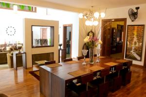 a dining room with a large wooden table and chairs at Mansion Square in Dehiwala