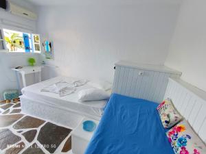 una piccola camera da letto con un letto bianco con lenzuola blu di Spasmata studios a Minia