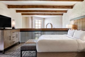 JW Marriott Scottsdale Camelback Inn Resort & Spa في سكوتسديل: غرفة نوم بسرير كبير وتلفزيون