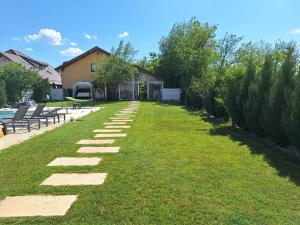 een gazon met stapstenen in een tuin bij Modern 3 bedroom house with a private pool in Popeşti-Leordeni