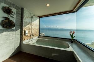 a bathroom with a tub with a large window at Neptune's Villa in Haad Rin