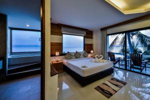 a bedroom with a bed with a view of the ocean at Neptune's Villa in Haad Rin