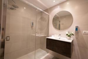 uma casa de banho com um chuveiro, um lavatório e um espelho. em Hotel Mediterráneo em Estepona