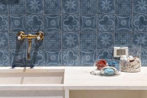 baño con lavabo y pared de azulejos azules en Marettimo Vacanze, en Marettimo