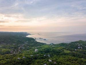 an aerial view of the ocean and a city at Casa La Distancia Mazunte Sustainable House in Mazunte +25 photos