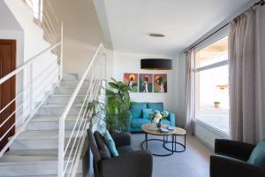 sala de estar con sofá azul y escaleras en Hotel Mediterráneo, en Estepona