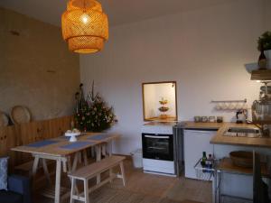 uma cozinha com uma mesa, um lavatório e um fogão em Mirathe em Baleyssagues