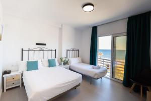 a bedroom with a bed and a view of the ocean at Hotel Mediterr&aacute;neo in Estepona
