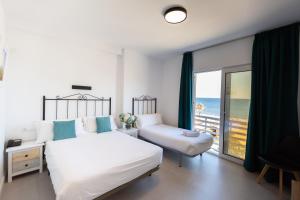 um quarto com uma cama e vista para o oceano em Hotel Mediterráneo em Estepona