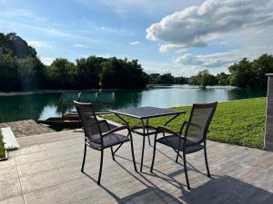 a table and two chairs on a patio near a lake at Terra Solis Bihać Villa 1 in Bihać