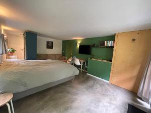 een slaapkamer met een bed en een groene muur bij La Grange 28 in Bergen op Zoom