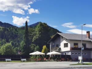 a building with tables and umbrellas in front of a mountain at One1-Apartments in Kötschach