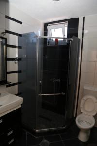 a bathroom with a glass shower with a toilet at Hotel Venisi in Prizren
