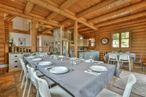 a dining room with a long table and white chairs at Eagle's Nest in Saint-Faustin