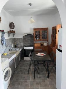 a kitchen with a table in the middle of it at Kanala house in Kithnos
