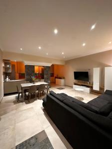 a living room with a black couch and a table at Appartamento “Amelia” Sperlonga in Sperlonga