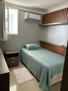 1 dormitorio con 1 cama con edredón verde en Belíssimo apartamento a 01 km da litorânea, en São Luís