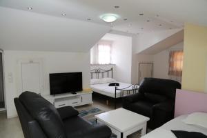 a living room with a couch and a tv and a bed at Hotel Venisi in Prizren