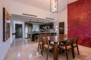 莫雷洛斯港的住宿－Luxury Beach Residences，用餐室以及带木桌和椅子的厨房