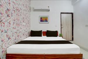 sypialnia z dużym łóżkiem i tapetą w kwiaty w obiekcie OYO Hotel Royal Park w mieście Alwar