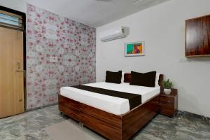 sypialnia z łóżkiem i czerwono-białą ścianą w obiekcie OYO Hotel Royal Park w mieście Alwar