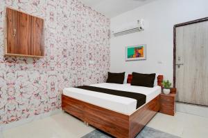 sypialnia z łóżkiem i tapetą w kwiaty w obiekcie OYO Hotel Royal Park w mieście Alwar