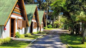 uma fila de casas com telhados verdes e uma estrada em Villa Chalés Gramado - OH HOTÉIS em Gramado