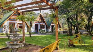 格拉馬杜的住宿－Villa Chalés Gramado - OH HOTÉIS，院子前有喷泉的房子