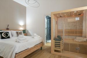 een slaapkamer met een bed en een glazen douche bij ThreeMoonsBoutique House/Pandora in Salerno