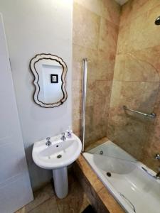 a bathroom with a sink and a shower and a toilet at Ceres Cozy Cottage in Ceres