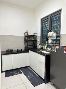 una cucina con piano di lavoro in bianco e nero di Holiday Inn Stay 3B2R Meritus Residensi Perai a Perai
