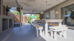 a patio with benches and a table on a building at Stay at Percy Self Catering House in Nelspruit
