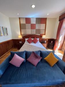 a bedroom with a blue couch with colorful pillows at Pepe's House Cuenca I Hotel & Boutique Hostel in Cuenca