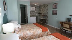 1 dormitorio con 2 camas, mesa y escritorio en The Savannah Inn, en Carolina Beach