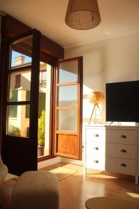 a living room with a television and a dresser with a window at El Maltés in Cudillero