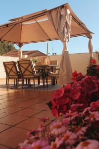 a table and chairs under an umbrella on a patio at Alojamiento “El Maltés” in Cudillero