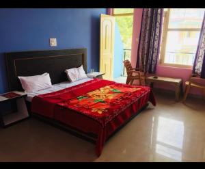 a bedroom with a large bed with a red blanket at Mcleodganj Diaries Homestay in Dharamshala
